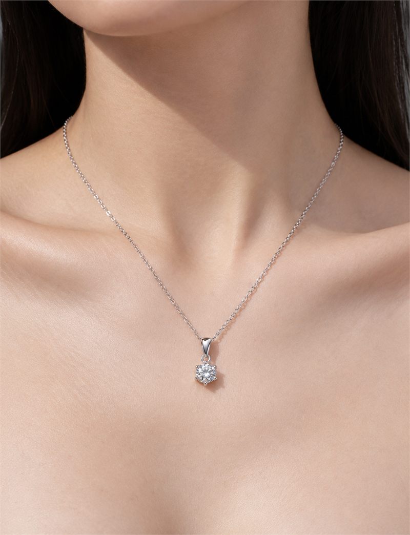 Worn on bare skin, close to the collarbone
